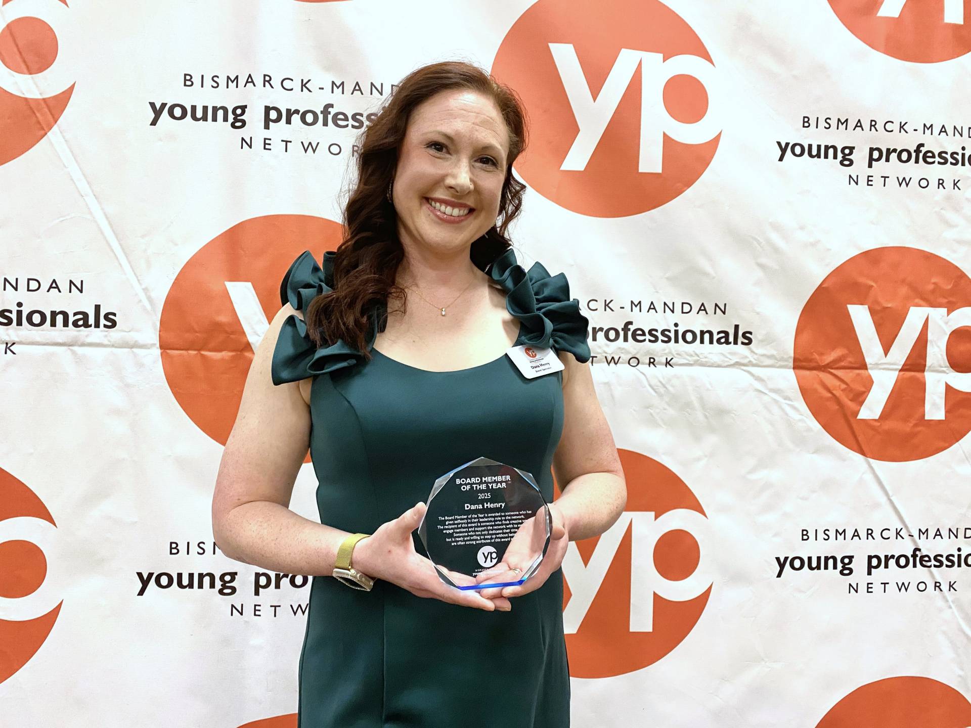 Henry, dressed in an emerald-colored gown, poses proudly with her Board Member of the Year award, presented by the Bismarck-Mandan Young Professionals Network.