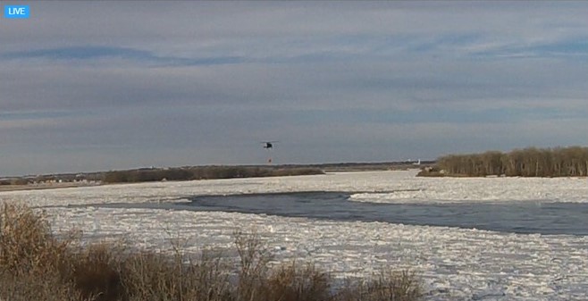 view of helicopter flying over the river ice jam